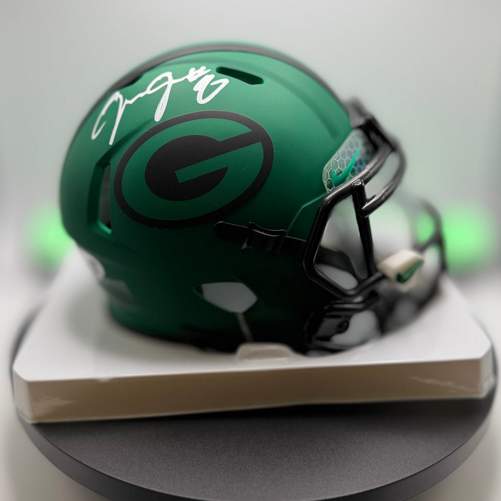 Green Bay Packers mini helmet on a white stand with a signature.