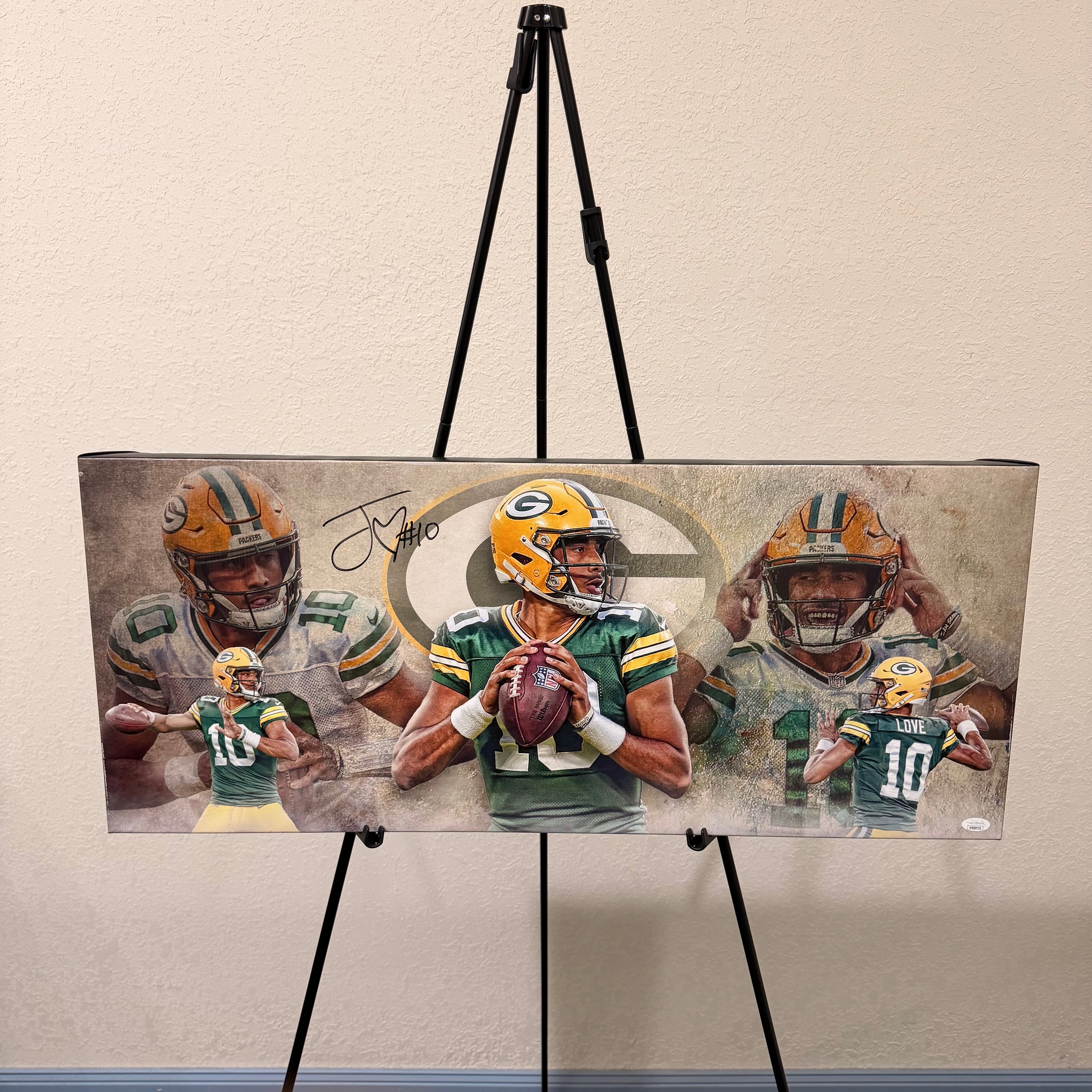 Canvas print of a football player holding a ball on an easel against a beige wall.