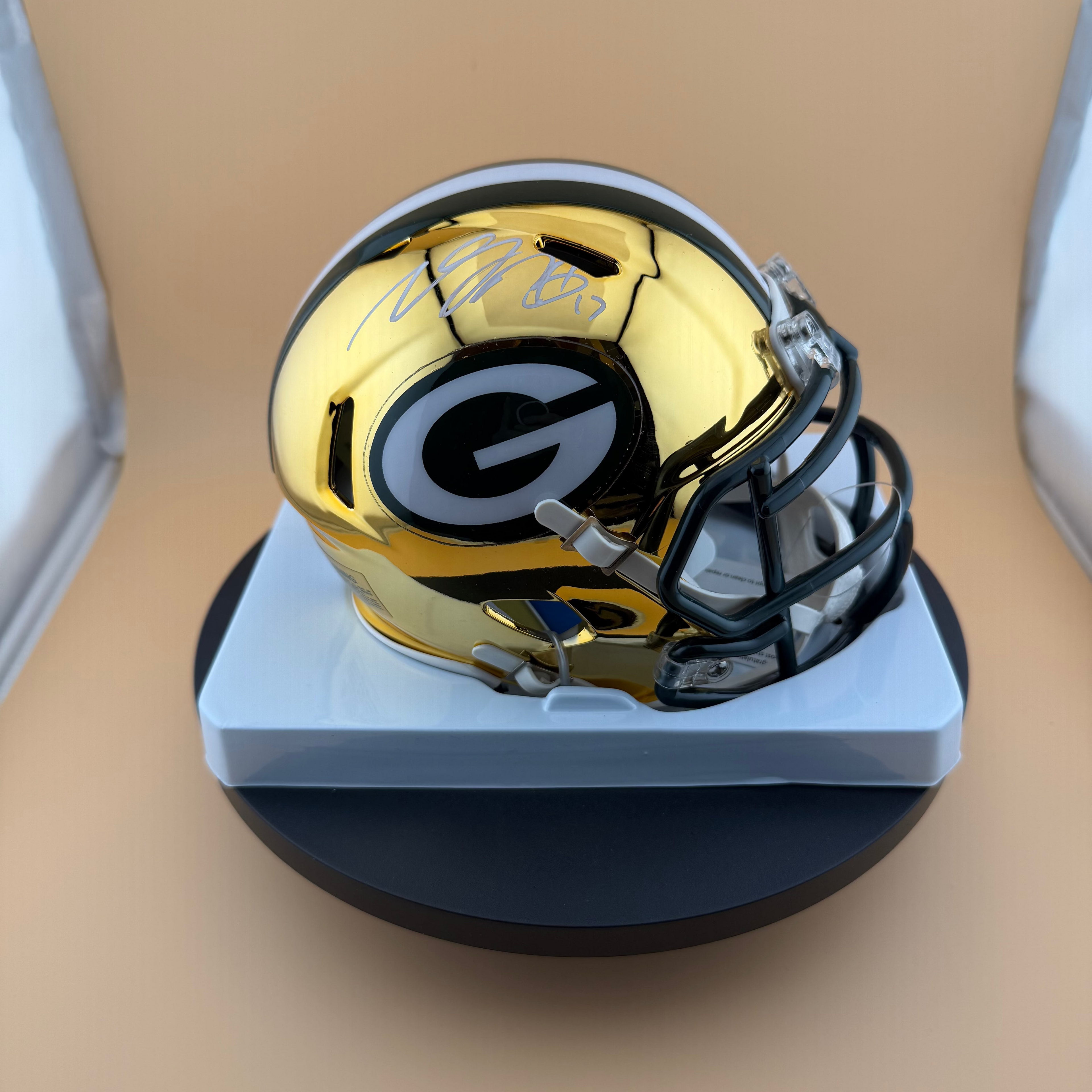 Gold and black football helmet on a beige background