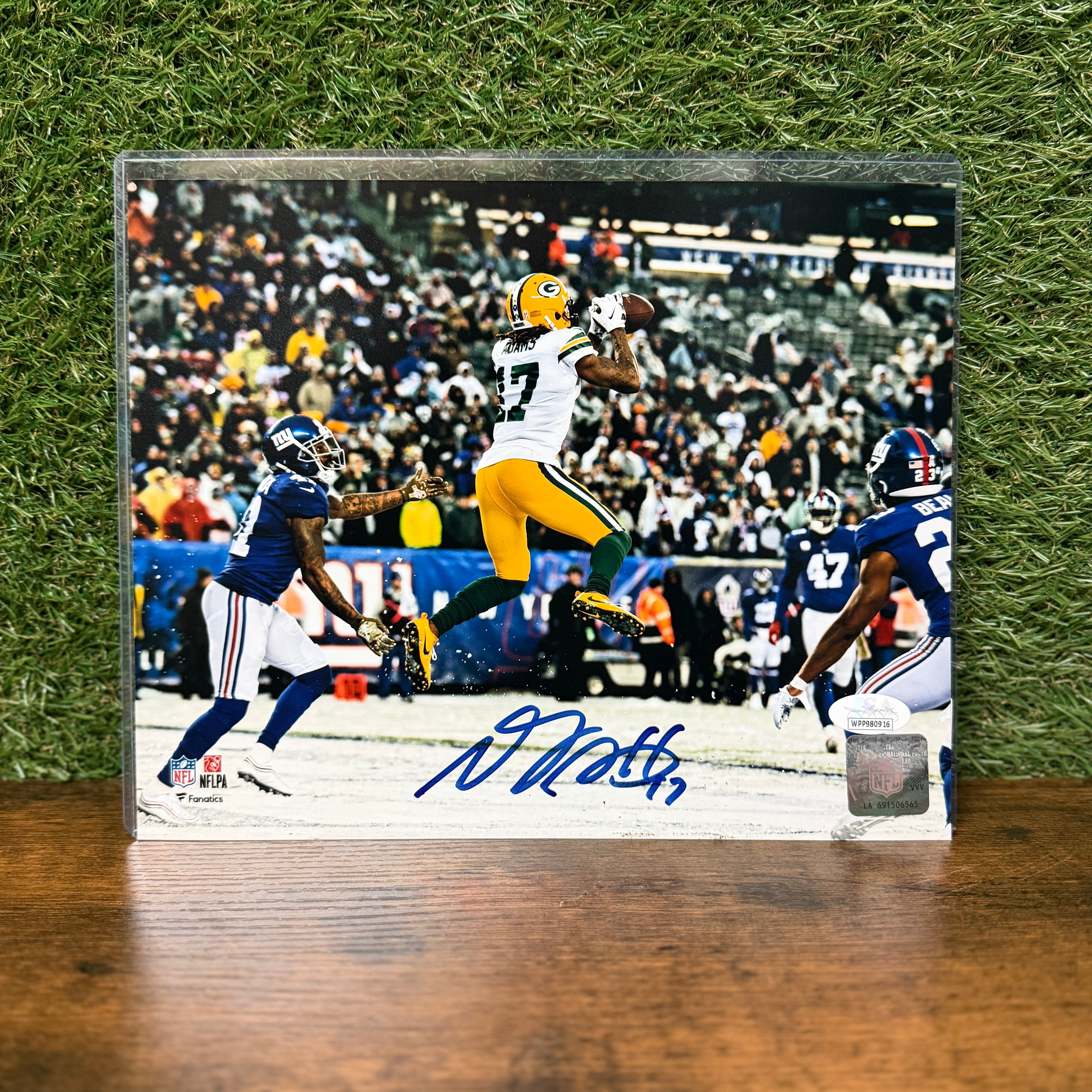 Autographed football photo of a player in action on a grass background