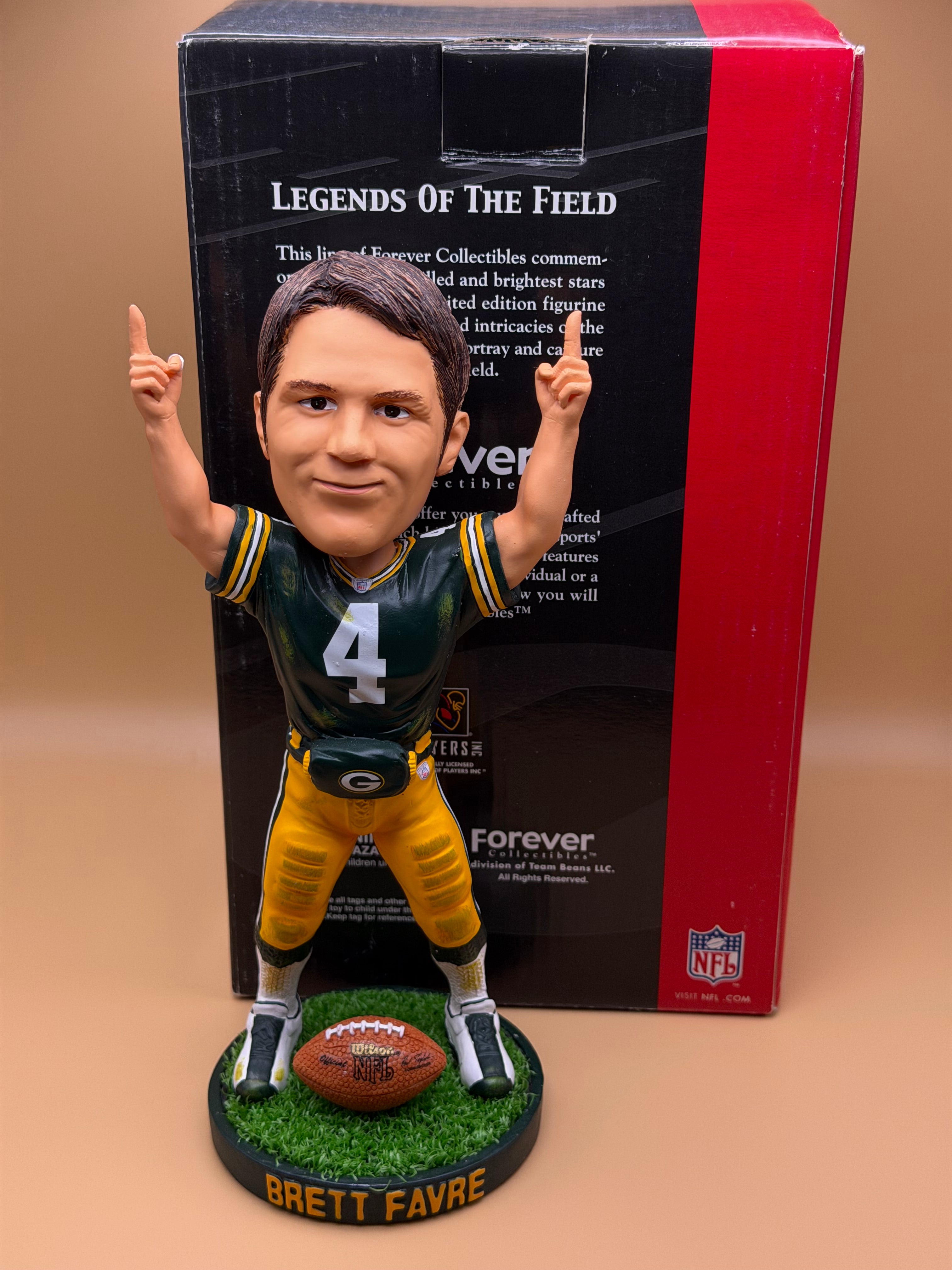 Football player figurine with a box labeled 'Legends of the Field' on a beige surface.